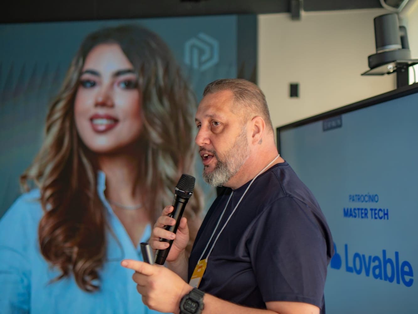 Luciano Passaretti palestrando em evento, com telão ao fundo, patrocínio Lovable e Master Tech