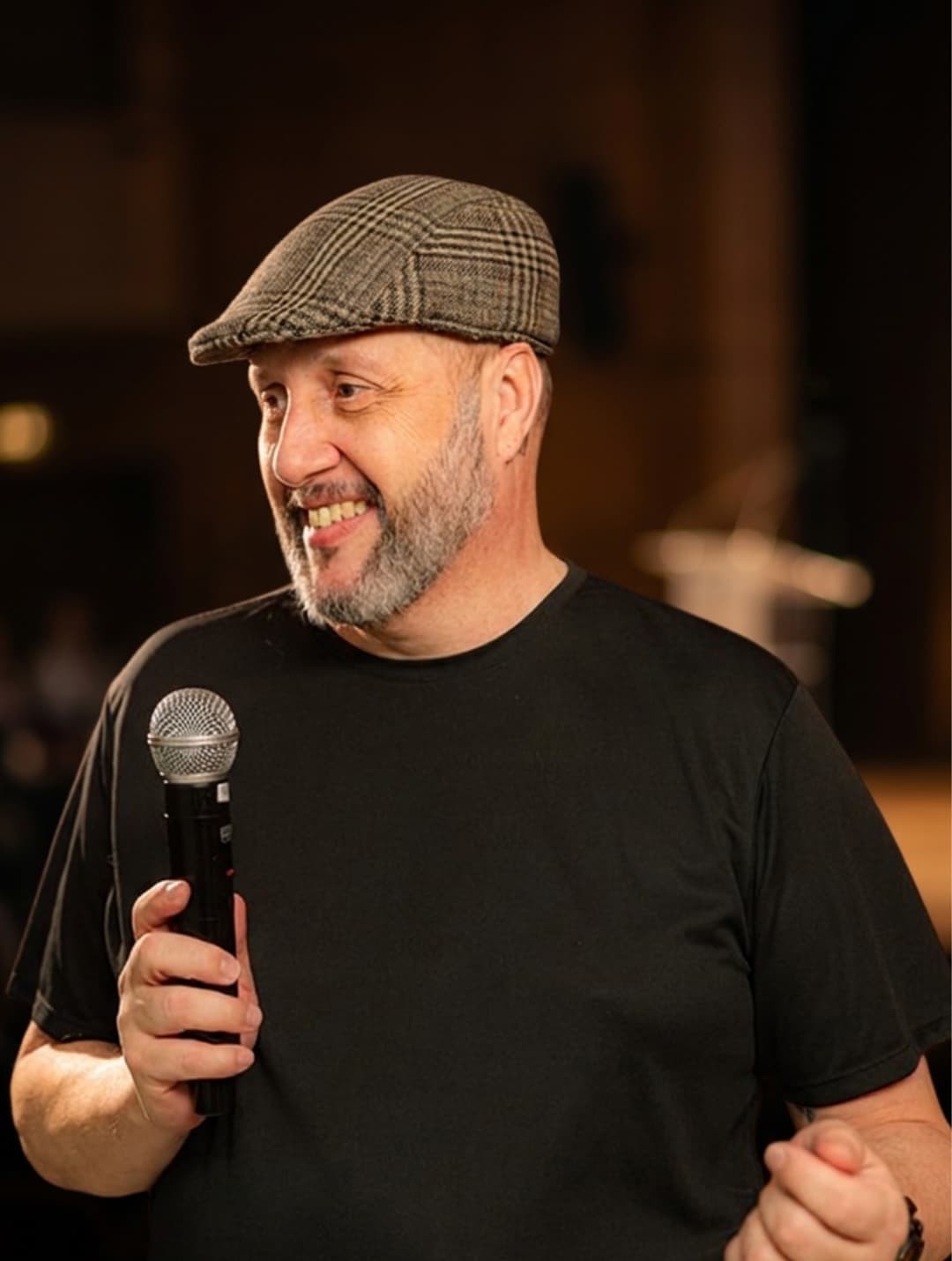 Luciano Passaretti palestrando, microfone em mãos, sorrindo